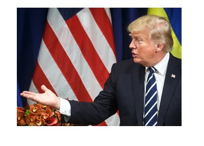 President of United States, Donald Trump, expressing himself in words and with a hand gesture in front of flags of United States and Ukraine.