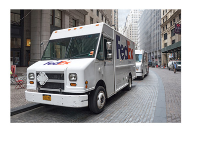 The Fedex truck ripping throught the streets of a big city in the United States of America