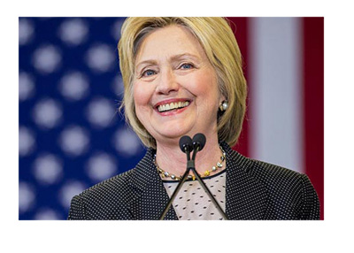 2016 elections - Campaign photo - Hillary Clinton smiling in front of an American flag