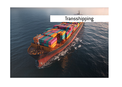In photo: Cargo ship is travelling the Ocean waters. The meaning of the term Transshipping is explained.