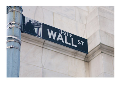 New York - Wall Street street sign in front of a white building wall